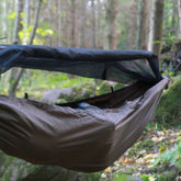 DD Travel Hammock / Bivi with built-in mosquito net, suspended in a forest setting, perfect for outdoor camping.